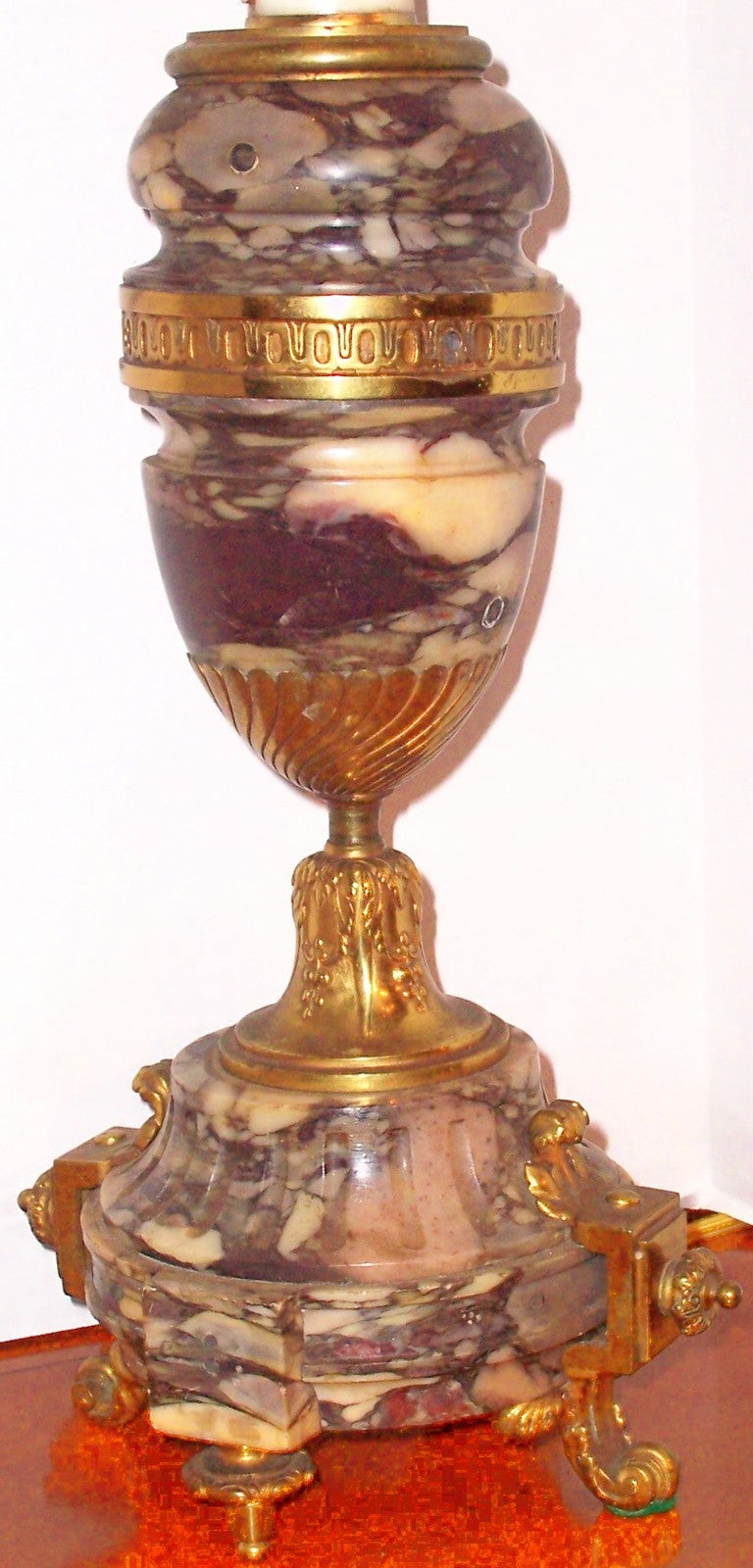 The tall turned marble urn form in a swirl of cream and varying shades of purple , lavender and violet . Probably with handles originally , now removed and holes filled . 

14 inches tall to top of urn (excludes lamp fittings )