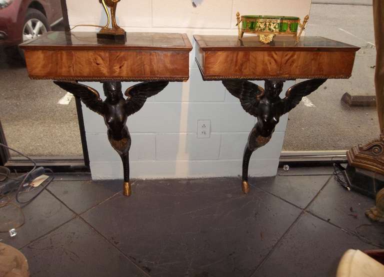 with winged sphinx like women in dark green -black paint (faux bronze )  ending in gilt hoof feet . The skirt in faded walnut with green inset tops. 

Unusually tall fcr consoles........

27 wide
16 deep
38 high