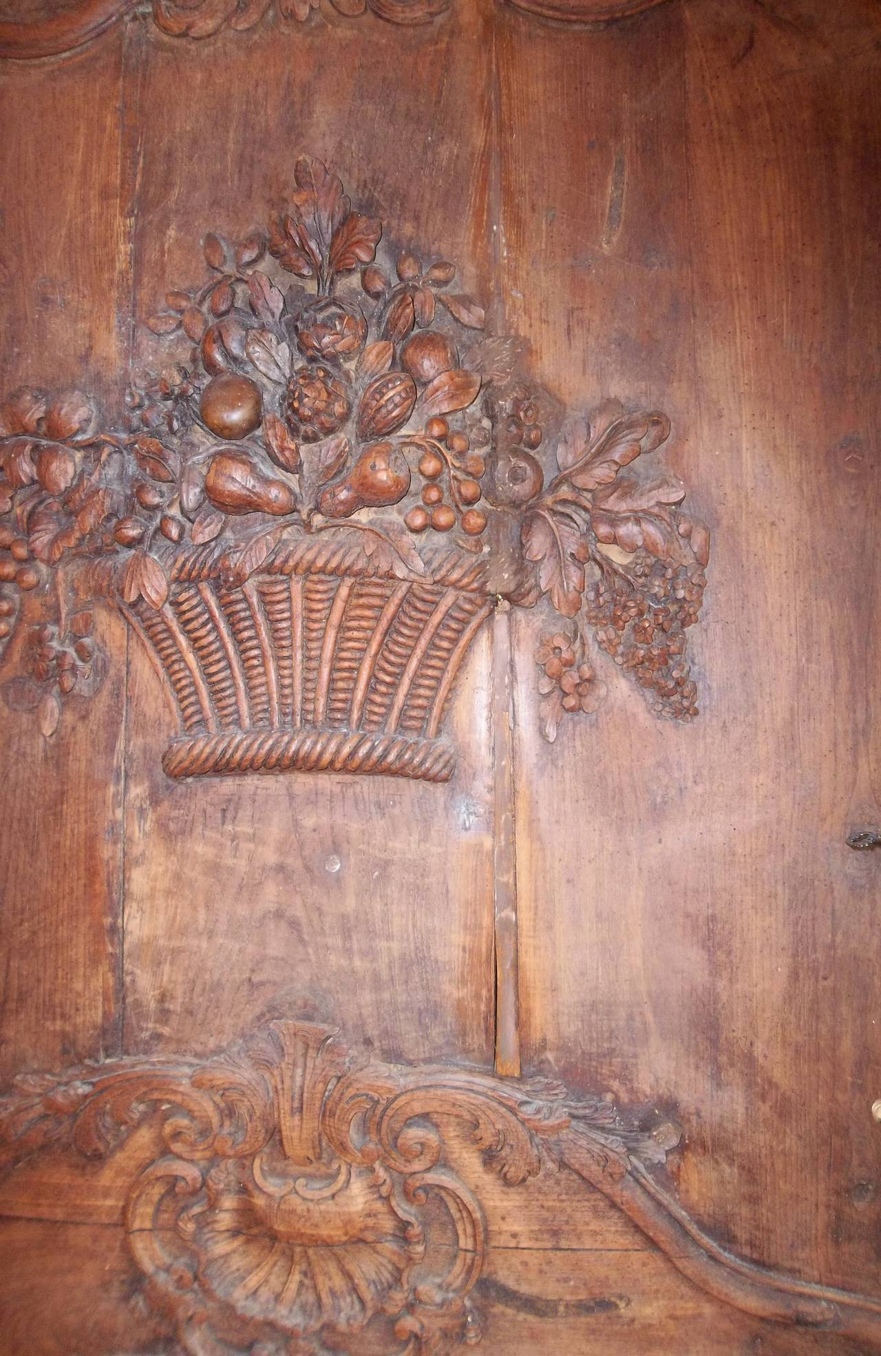 With a distinct central bow . The outer carving of typical Rococo floral and rocaille shell motifs. The center with a basket of fruit and flowers.  Probably a chimney breast . Faded and dry lacking a finish . When oiled or wet , a rich walnut color 