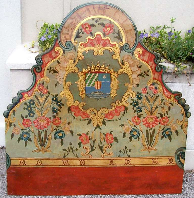 Colorful armorial panel , probably cut from a boiserie (wall paneling ) .Pompeii red with  florals motifs shaded in pink and blue with foliate stems in dark green and gold leaf against a mint green ground . Rocaille shells and  'C' scrolls