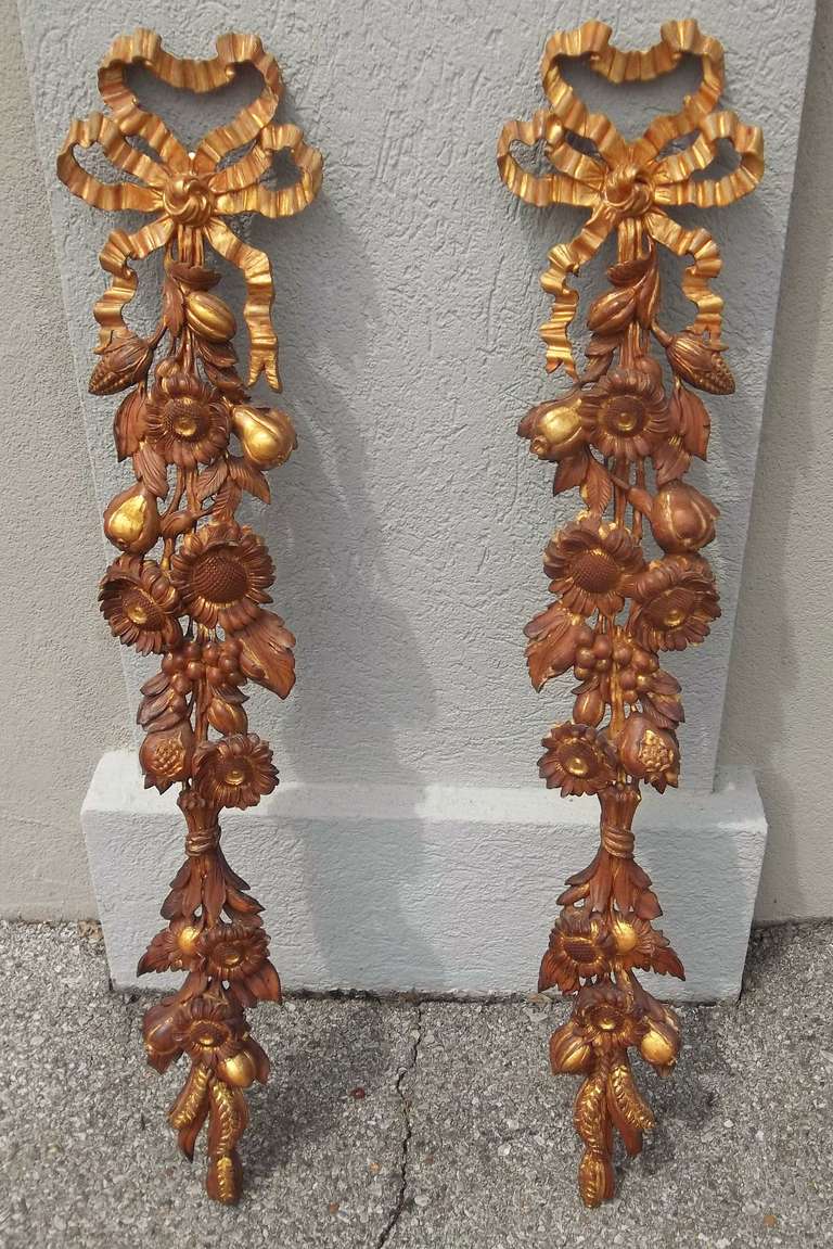 Pair of carved fruit and floral walnut festoons with gilt ribbons. Manner of Grinling Gibbons ..
Could be converted to sconces.
Stamped Italy , probably for export Market