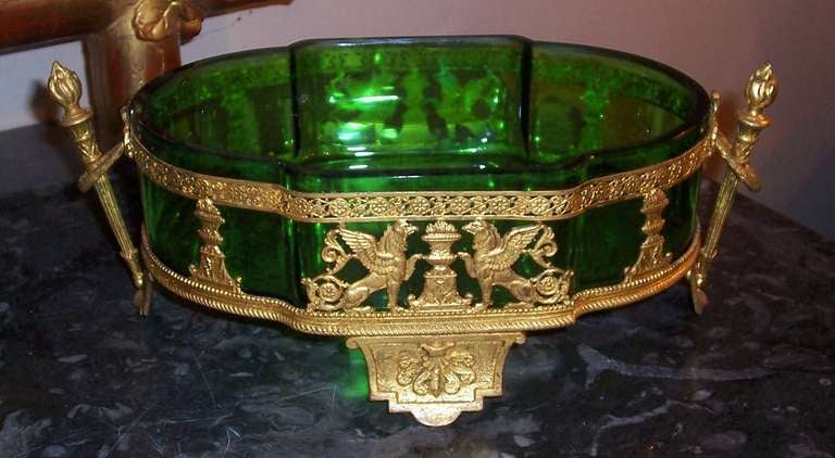 A large rich First Empire green (or emerald  if you prefer ) compote with bronze mounts  with traditional empire motifs ( winged lions , urns , torches ).

In very good shape, the glass with no chips.
measures 4