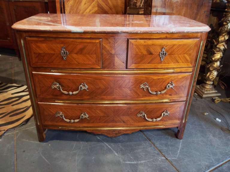 A Regence style tulipwood commode with bronze pulls and double beveled conforming rouge marble. Brass stiles under each drawer and 3 at each corner .
The tulipwood laid in quarter panels on each drawer and each side.
Very pretty cognac color and
