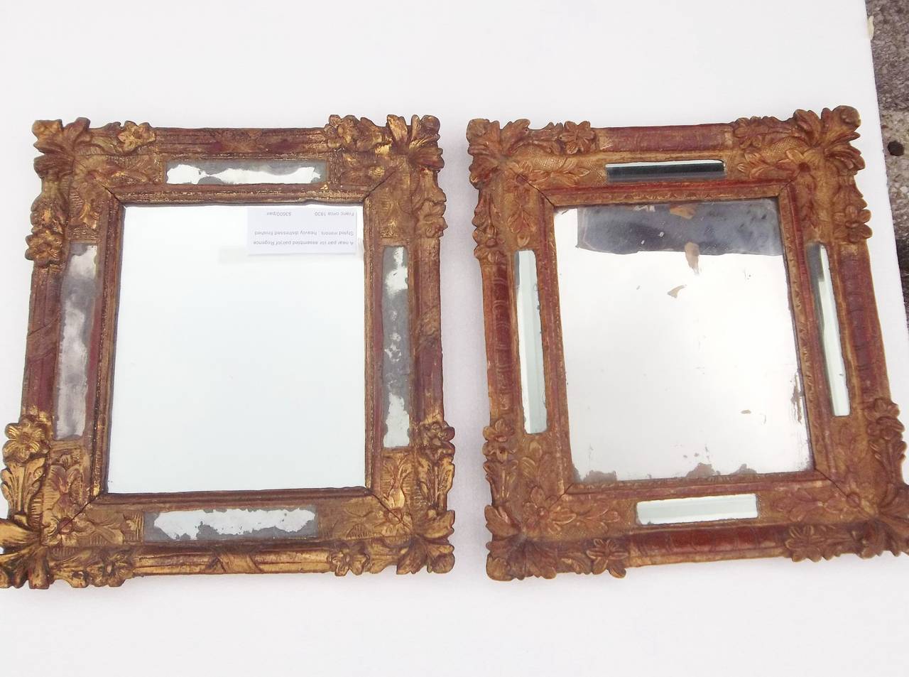 Pair of mid-19th century mirrors with repairs restorations, attractive distress.
Nearly identical size and pattern to frames 

One mirror with 4 beveled mirror flanking styles.  Red bole prominent color.

One mirror with 4 styles (and central