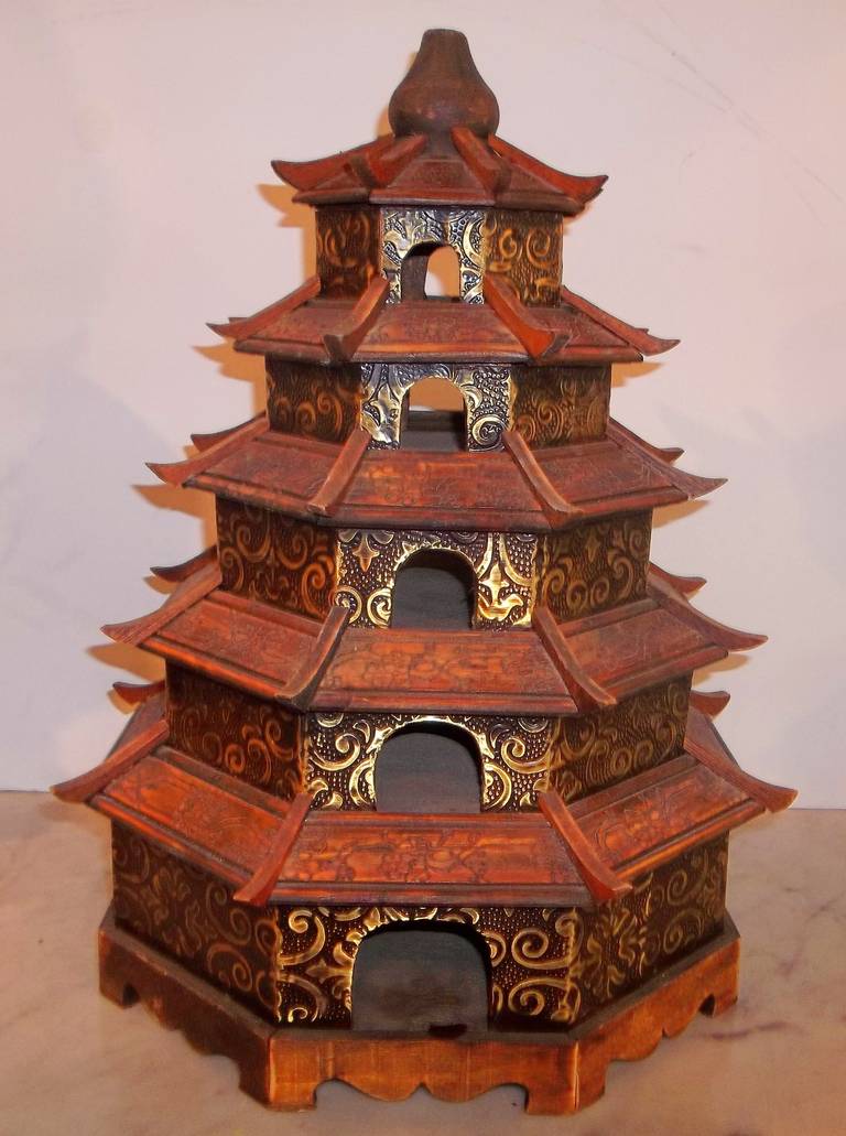Highly decorative pagoda form. The roof with engraved panels. The polychrome apparently pressed and applied tin. Popular for house canaries, possibly made for export market.More of a house nest than a real cage .
