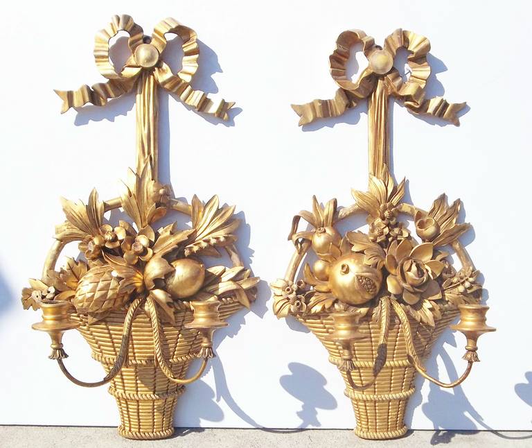 Pair of French or Italian boldly carved wood baskets of fruit and flowers, fitted with sconce arms. Minor bleeding to red and yellow basecoats. Some build up of dust in deeper crevices. Minor chips, nicks, age and use wear.