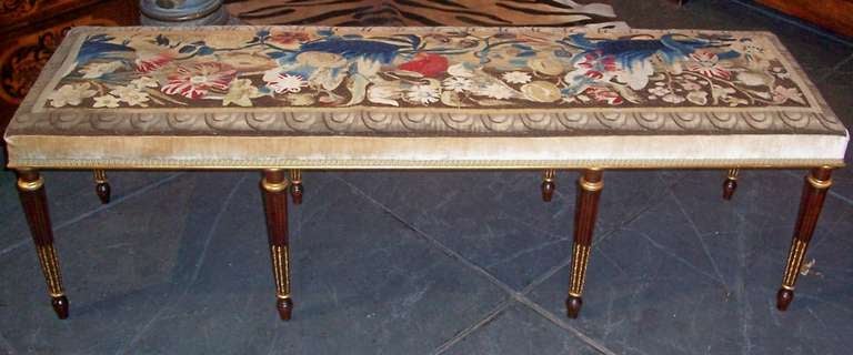 The mahogany carved legs mounted with gilt rings, the flutes with gilt bell flowers ending in a toupie foot variation . The covering a vibrant 17th century Flemish fragment (light wear) beige velvet for the sides .  Sturdy frame .

The tapestry is