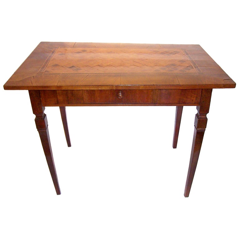An Italian provincial parquetry decorated walnut and fruitwood side table. The top in geometric parquetry, double banded and encased in walnut. The shaped legs pegged joined. Very good mottled color and fading with a nice polish. Overall some