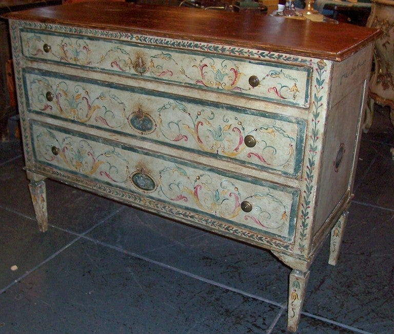 Typical continental commode , paint embellished in manner similar and typical of Italian cities Florence and Venice. A beveled faux porphyry top. Neoclassical shaped and formed legs . Paint rubbed, worn , slightly dingy from time and use. Highly