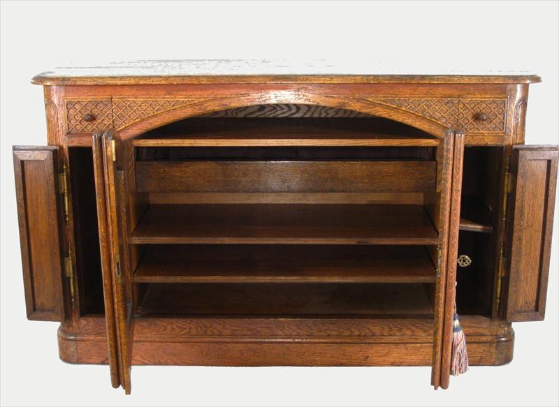 Provincial Style Oak Buffet in Louis XV taste, oblong top with rounded four corners projecting over a paneled case fitted with two small frieze drawers over a pair of narrow doors centering a pair of arched doors opening to a fitted drawer over