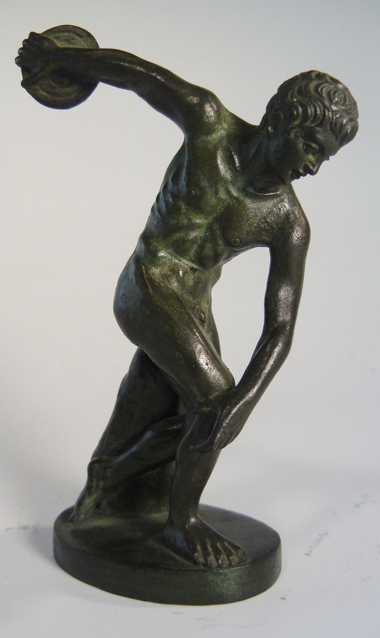This is an excellent bronze desk-top-sized Grand Tour Souvenir figure of the Discobulus modeled after the antique original by Myron. This Olympian discus thrower has a dark green patina and the casting is crisp with fine detail, and with a surface