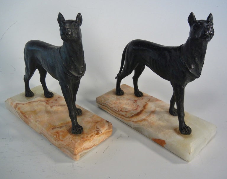 Especially made for animal lovers, this graceful pair of Spelter bookends depicting alert Great Danes are mounted on striated and beveled marble plinth bases, with excellent, crisp casting and expert modeling of the dogs.

These functional objets