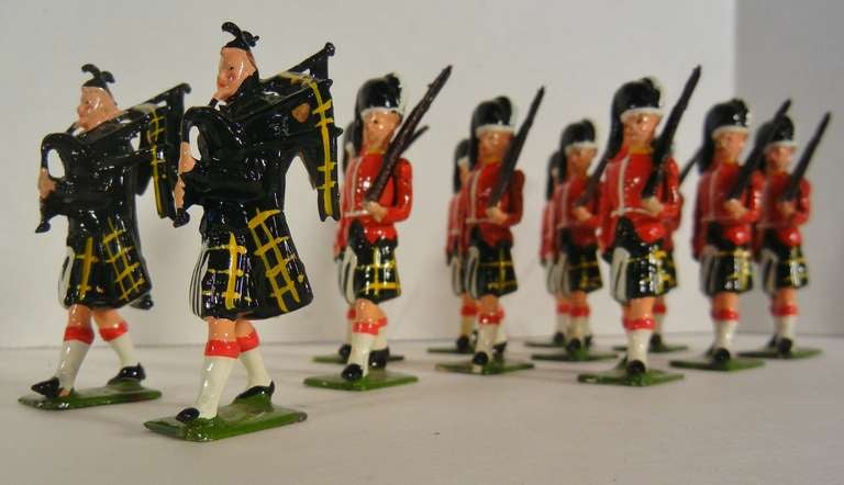 A twelve-piece grouping of two hollow-cast sets of W. Britains Ltd. catalog #77 Gordon Highlanders (marching at the slope) with Piper.

Each of the two sets contains five troops in red tunics with yellow facings and Gordon tartan kilts (yellow