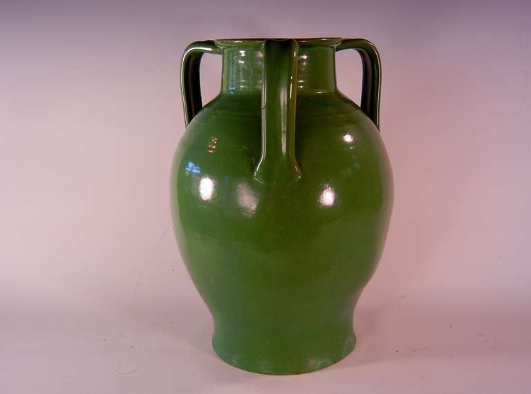 This porch vase in red clay with a Chinese Green glaze and three applied handles has unravelled-screen-wire marks on the bottom, which are evidence of its age as this technique of cutting the pot from the throwing wheel was used before 1939.

The