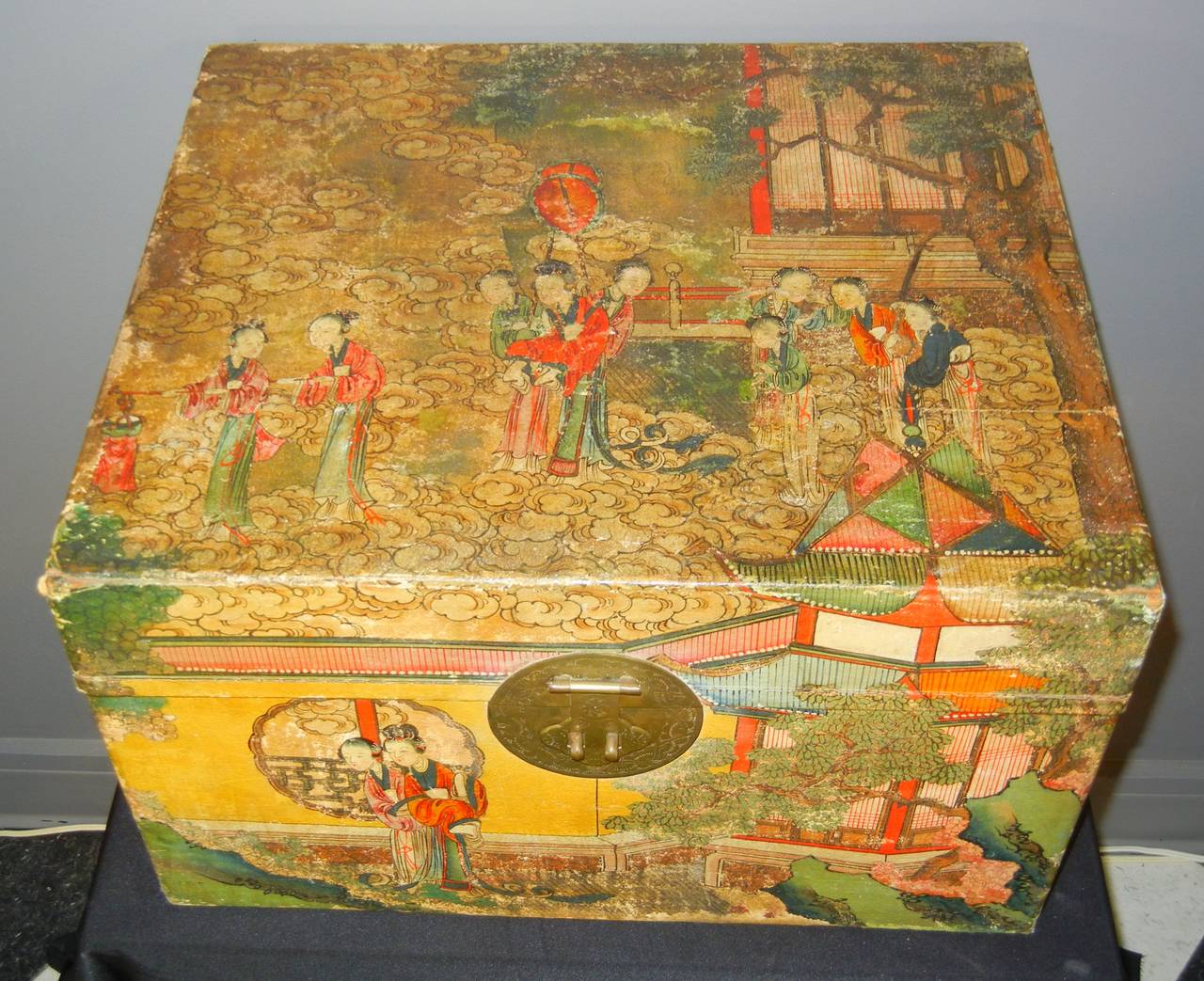 This Chinese travel trunk is composed of a camphorwood base covered by pigskin hand-painted with 19th century figures in traditional dress and hairstyles who inhabit landscaped gardens and courtly pavilions. The brass hardware includes hinges, two