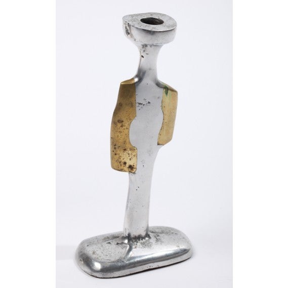 These candlesticks, an asymmetrical pair, from the Catalan Modernisme period are composed of sand-cast aluminum and bronze. Their surfaces reveal the sand of the casting process and are pitted and rough in a naturalistic manner. The bronze adds