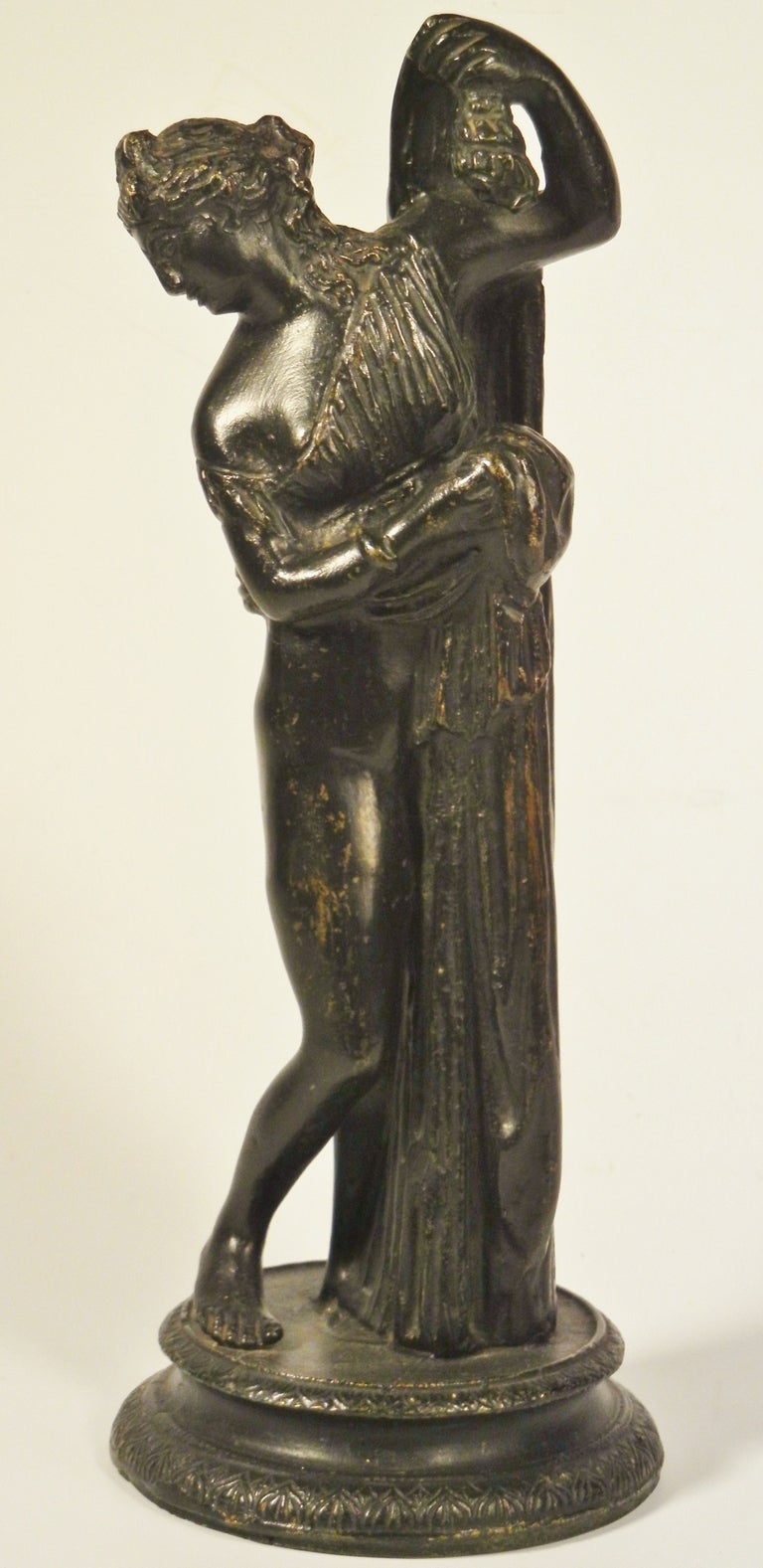 This graceful tabletop bronze figure with its black patina depicts the 