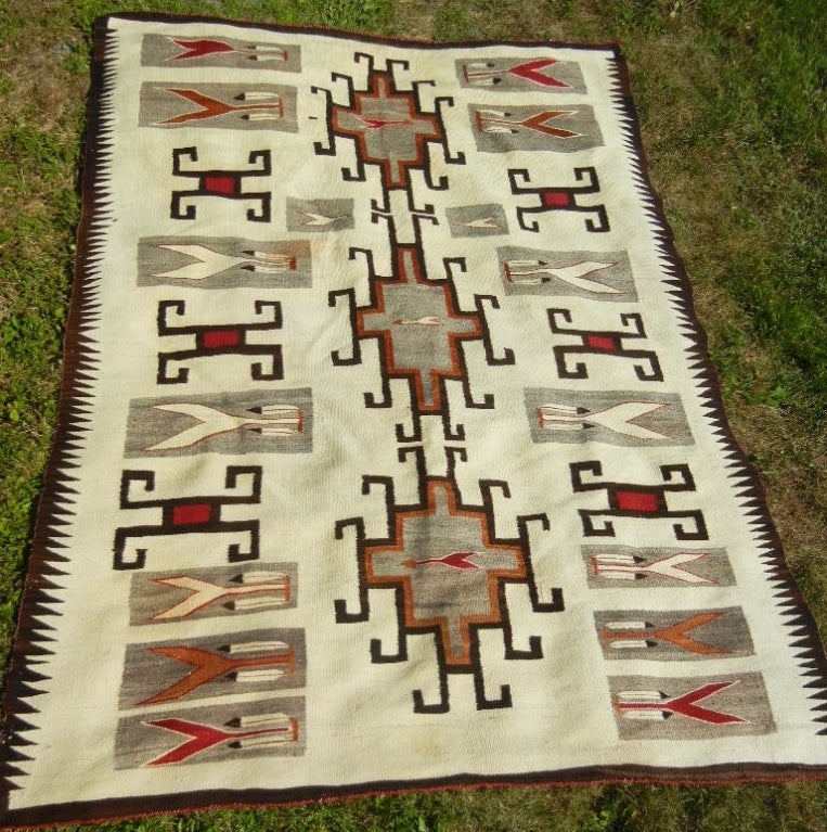 Vintage Navajo large-size woven rug purchased in the early 20th century at the Klagetoh Trading Post of J.L. Hubbell in Klagetoh, Arizona. The striking features of this rug are the arrow-themed motif with feathers, the red and brown stylized spiders