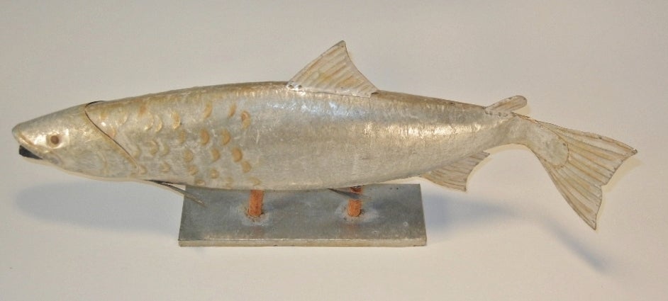 Realistic, life-size hand-made model of an Atlantic Salmon in hammered, cut and shaped galvanized steel, with hand-made rivets and with painted highlights, mounted on two wooden dowels which are inserted into a hand-made galvanized steel base. This