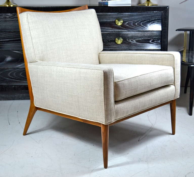Classic pair of mid-century modern lounge chairs designed by Paul McCobb for Directional. Signature walnut frames in excellent restored condition complimented beautifully by new beige tweed upholstery.