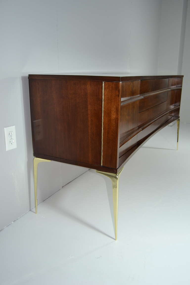 Walnut and brass mid century modern credenza. Walnut has been newly refinished in a medium tone, brass legs newly polished.