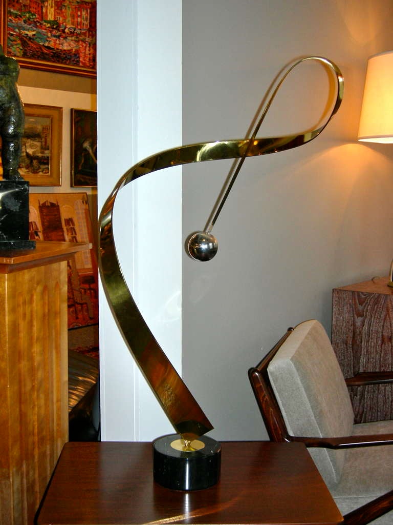 A fabulous brass and chrome on marble base abstract/kinetic ribbon like sculpture by Curtis Jere. Signed.