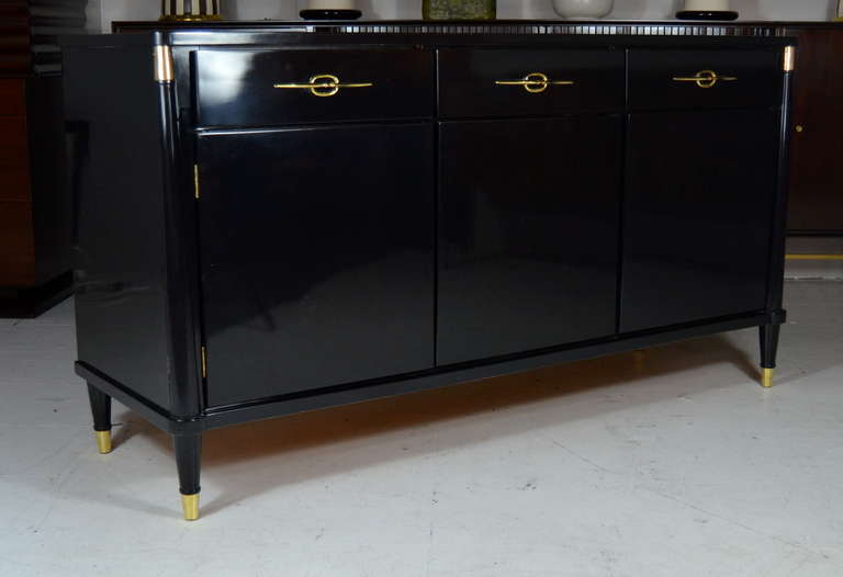 Mid-Century credenza newly done in black lacquer with brass accents and hardware.