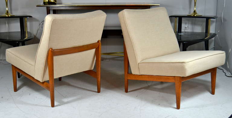 Pair of Danish modern teak framed floating lounge chairs newly upholstered in beige basket weaved fabric. Teak frames have been restored maintaining its beautiful patina.