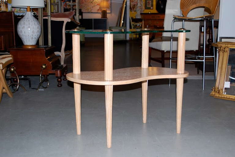 Table d'appoint à deux niveaux, en céramique, avec des pieds fuselés, le plateau en verre est fixé par des bouchons en laiton. Dans le style de Gilbert Rohde. Récemment rénové.