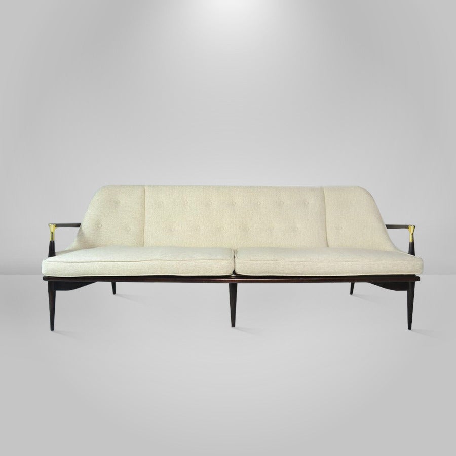 A rare Danish modern sofa attributed to Ib Kofod-Larsen manufactured in Denmark, circa 1955.

Featuring newly polished brass arm-tips details; re-upholstered in an oatmeal tweed. Sculptural walnut frame newly refinished in dark brown.