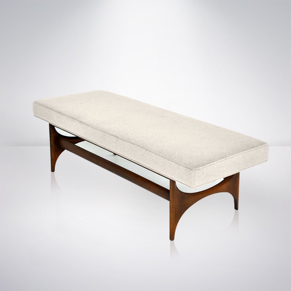 Very chic 1950s sculptural walnut base bench. Newly reupholstered in an ivory fabric. Walnut base refinished in natural.