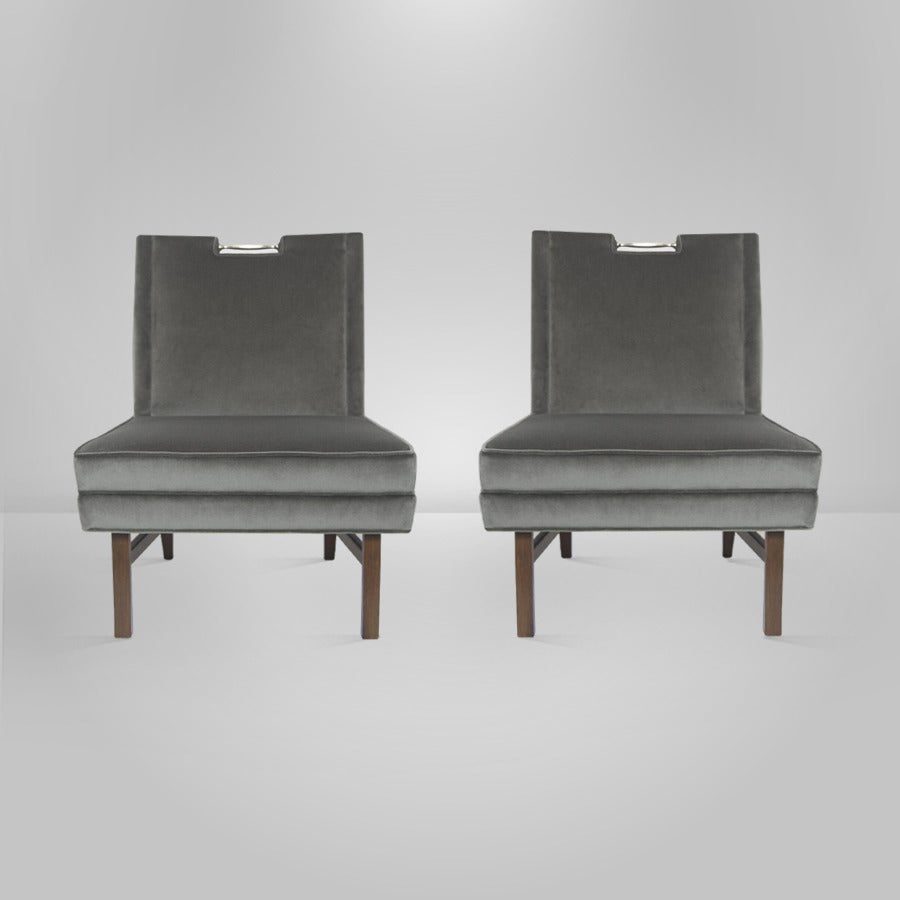 Rare pair of lounge chairs designed by Harvey Probber for Probber Inc. Newly upholstered on grey velvet, with walnut base newly refinished in dark. This pair features a very cool solid brass handle atop the chair of easy movement.
