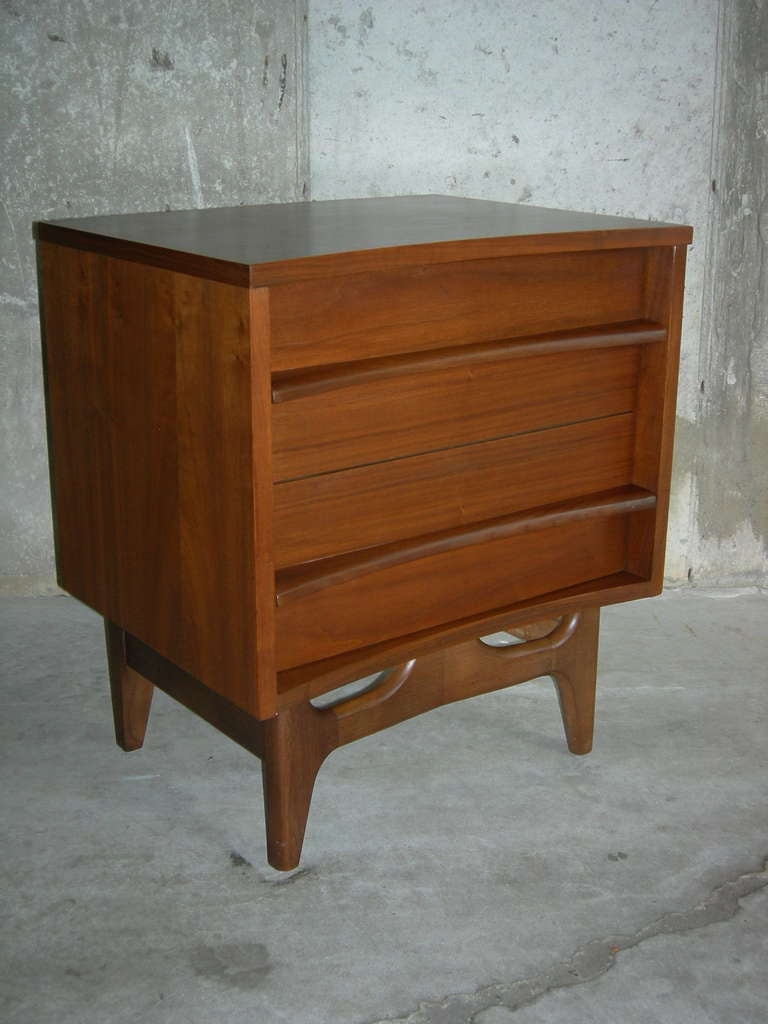 A pair of solid walnut sculptural, bow front nightstands.