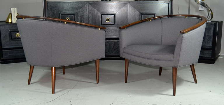 Pair of Italian barrel back lounges featuring brass risers and a floating walnut top. Newly upholstered in a smokey grey fabric.