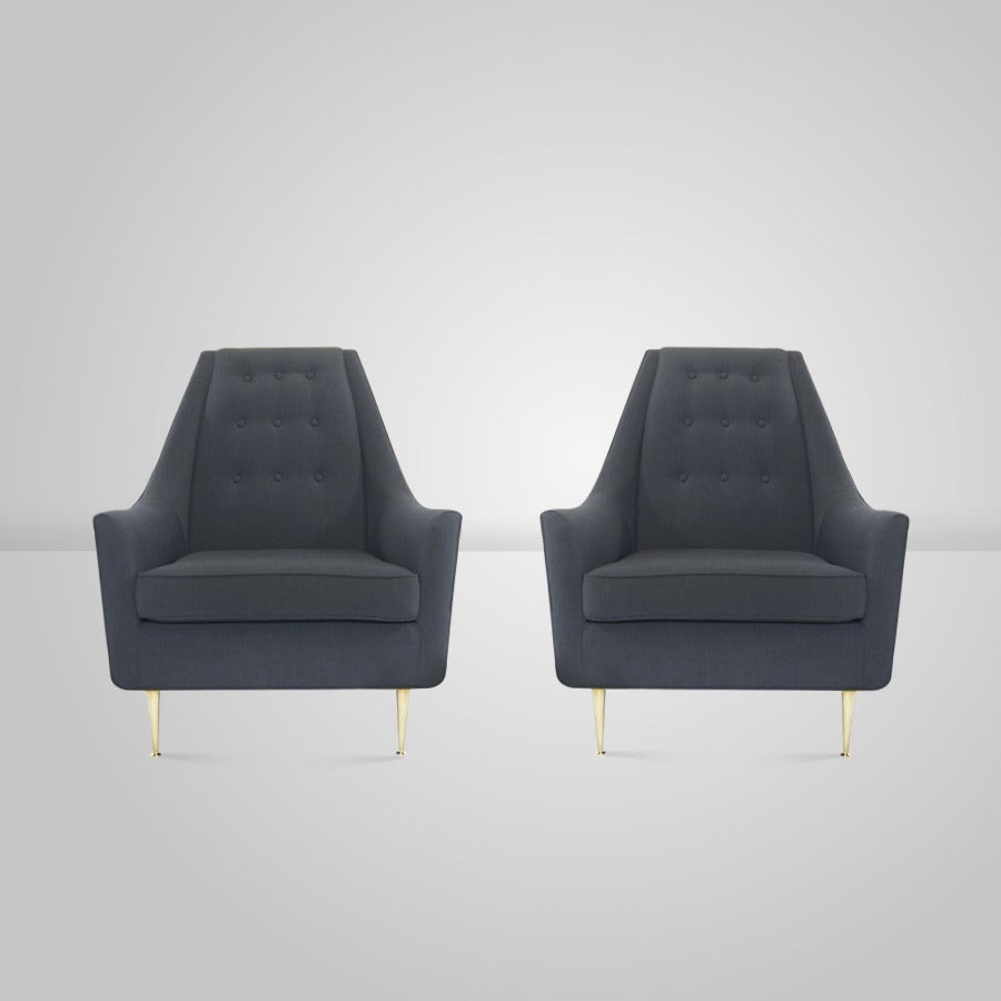 A large scale pair of lounge chairs on polished brass legs in the manner of Gio Ponti. Newly upholstered in navy blue linen.