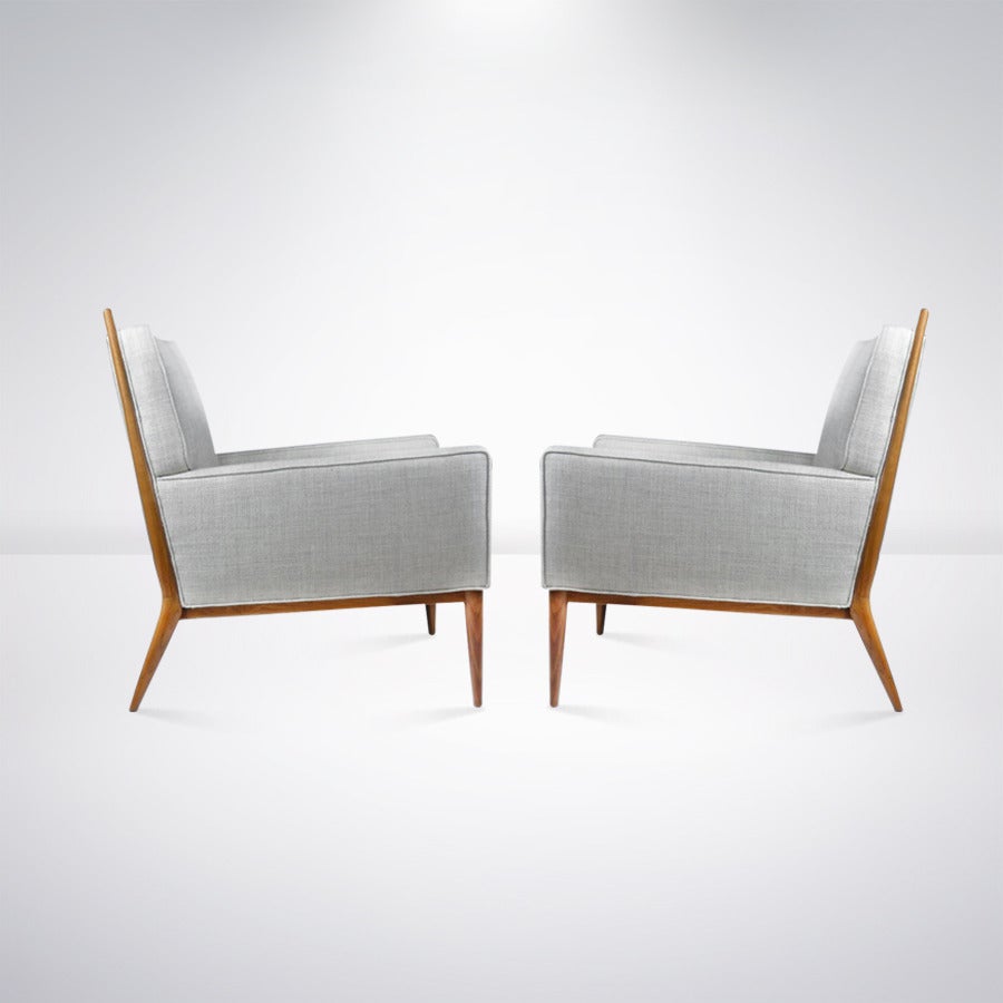 Classic pair of lounge chairs designed by Paul McCobb for Directional. 

Newly upholstered in an oatmeal twill. Walnut frames newly refinished and in mint condition.