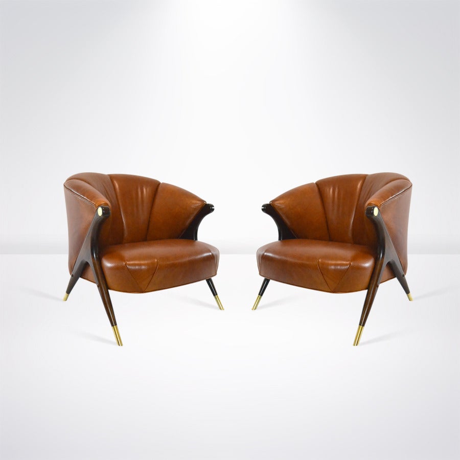 Pair of modernist lounge chairs, manufactured by the Karpen Company of California, circa 1950s. 

These have been completely restored, sculptural walnut legs newly refinished in medium brown, brass sabots and circular brass details on arms have