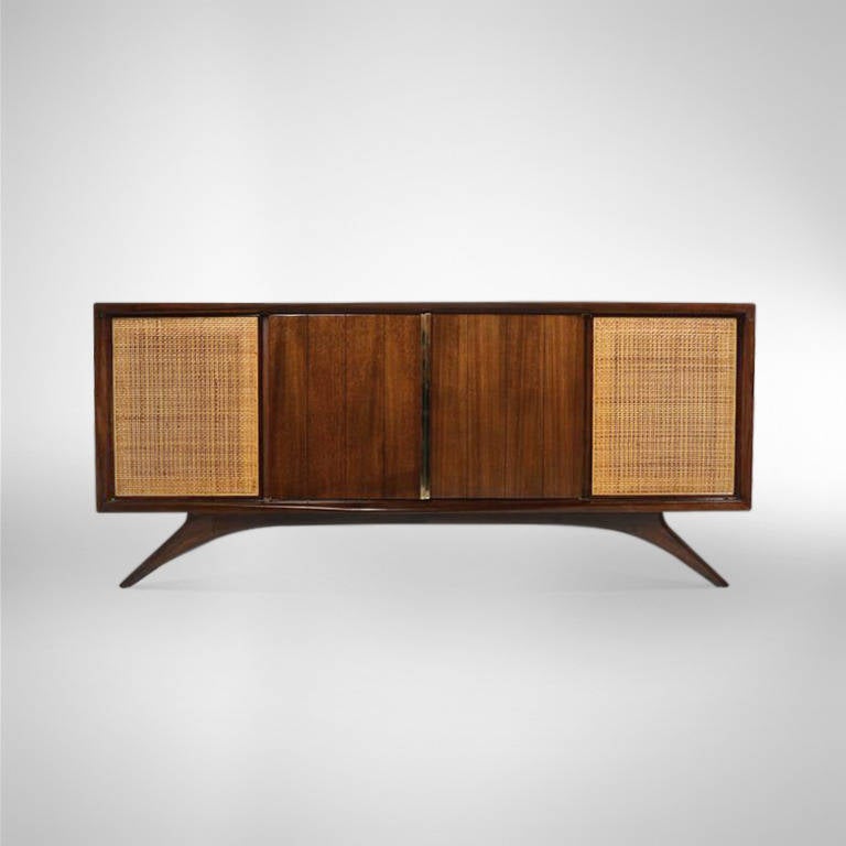 A superb credenza or sideboard designed by Vladimir Kagan for Grosfeld House, New York, circa 1950s. Walnut newly refinished in natural with cane side doors in perfect condition. Solid brass hardware newly polished.
