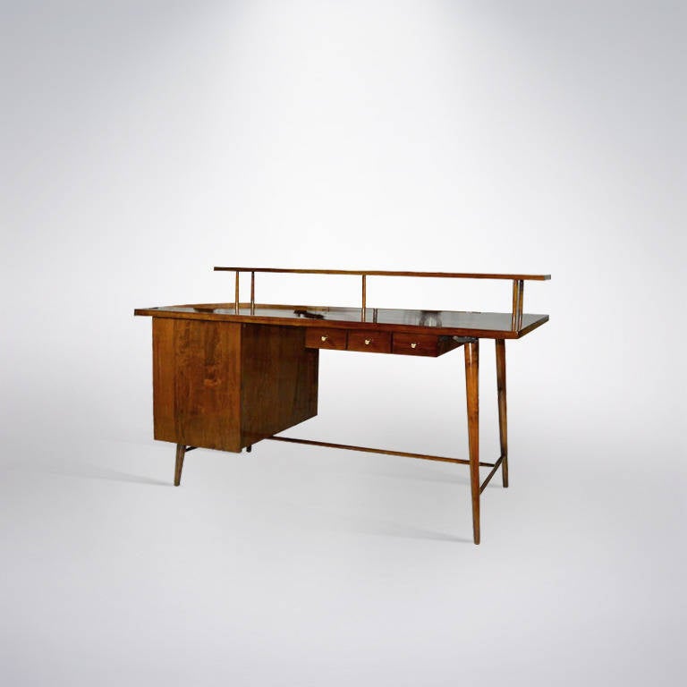 A very unusual desk featuring great architectural form designed by Paul McCobb newly refinished in medium walnut. 