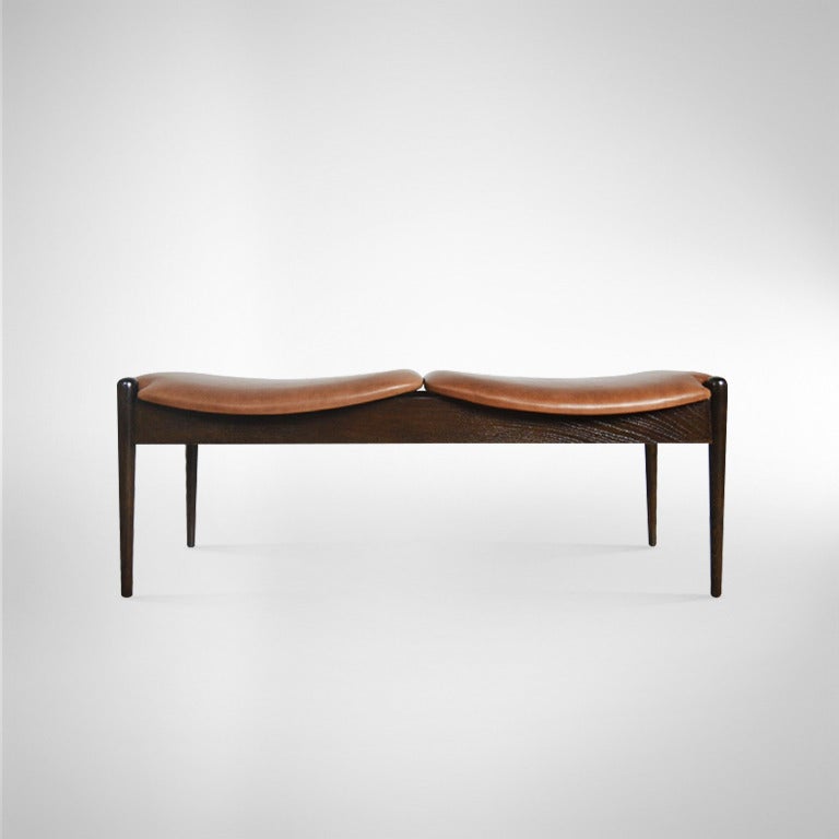 A handsome two-seater bench designed by John Stuart. Walnut frame newly refinished in deep dark chocolate, seats newly upholstered.