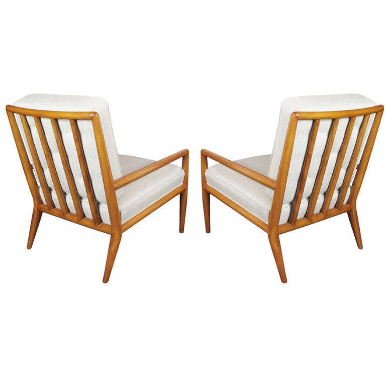 Classic pair of lounge chairs by T.H. Robsjohn-Gibbings for Widdicomb. Newly refinished in a medium walnut tone and upholstered in a beige linen silk blend. Reupholstery in COM available.