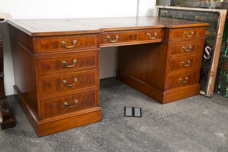 Beautifully made vintage British style burl yew wood desk with banded drawer fronts. There are 7 drawers including 2 file drawers. Gilt embossed mottled leather top in a fine camel color. Brass pulls.