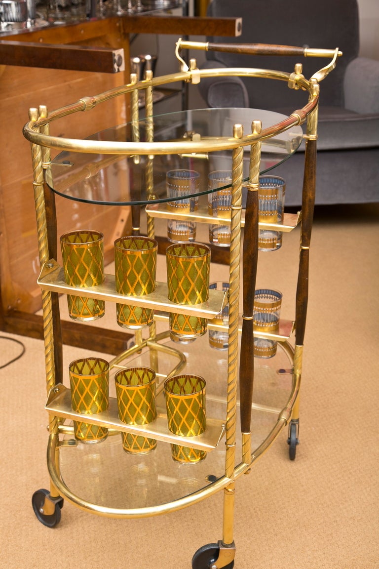 Definitely Mad Men! This almost Baroque Mid-Century Modern cart has all the bells and whistles. Swirl Brass columns and accents, swinging glass holders for 12, and a tri-section bottle holder (on bottom glass shelf). All original including glass.