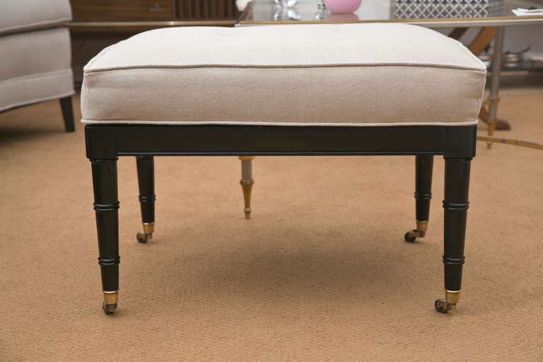 All original Mid-Century faux-bamboo bench in all original condition, including brass castors. Ebonized frame and custom, button-tuft upholstery in a quality linen.