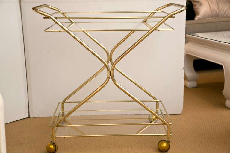 All original 1960's tiered brass bar cart. Super minimal lines with great, mid century style.  Slight all-over age patine only adds to the look and style of this great cart.