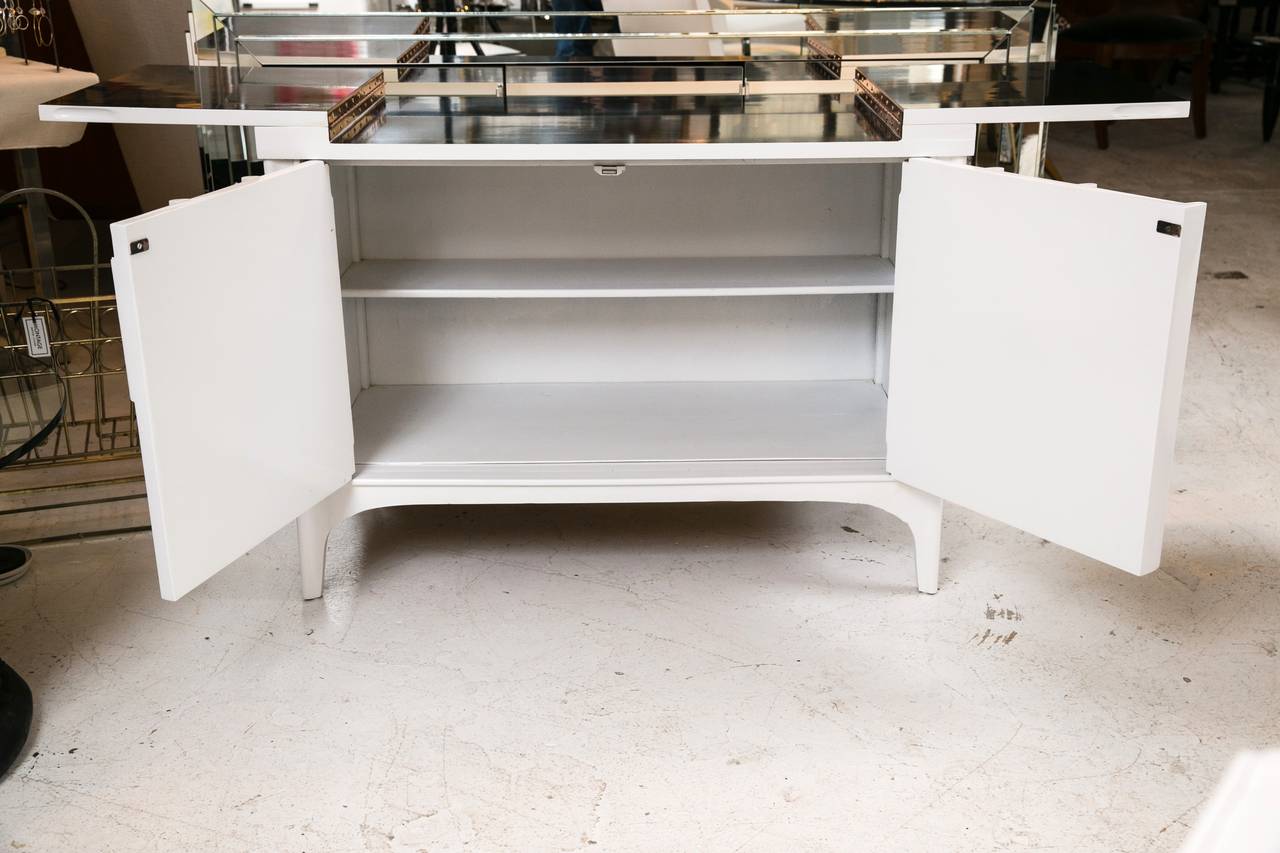 Gorgeous refinished Kent Coffey Perspecta bar console table with fold out black formica top for serving. Brought back to life with a chic white lacquer exterior as well as a finished white interior including a shelf.

Meticulously designed with