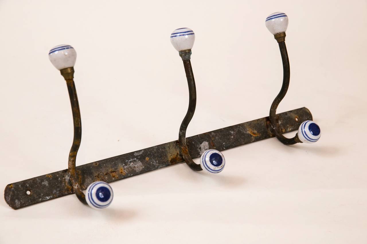 Perfect for the beach house, antique british coat/hat rack with porcelain finials.