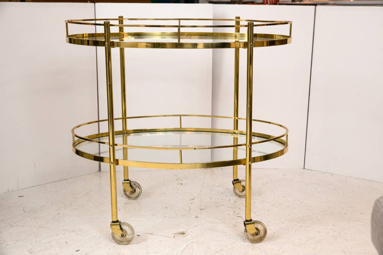 Classic 1940s oval solid brass galleried bar cart with beautiful proportions and in all original condition. Very well made, functional and lovely.
