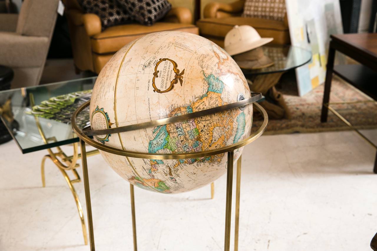 1970's Replogle Globe of the World on solid brass circular floor stand.  Designed by Paul McCobb, this highly collectible rotating globe pivots 360 degrees and retains its original texture and vivid colors. A great conversation piece for a study,