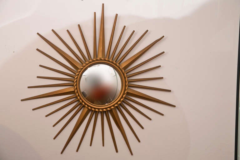 Diminutive gilt iron sunburst mirror with convex glass mirror signed Chaty Vaullaris.